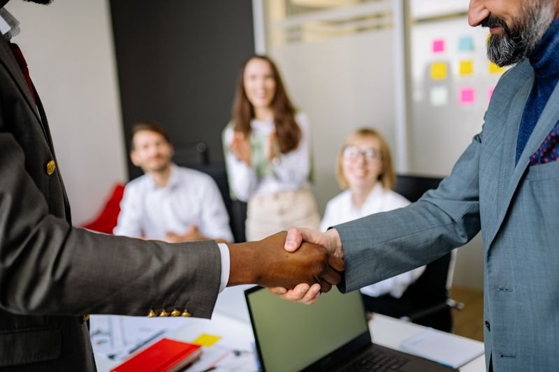 Two business professionals shaking hands in an office
