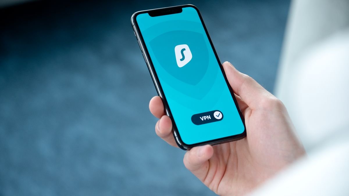 Person holding a smartphone showing a VPN security app
